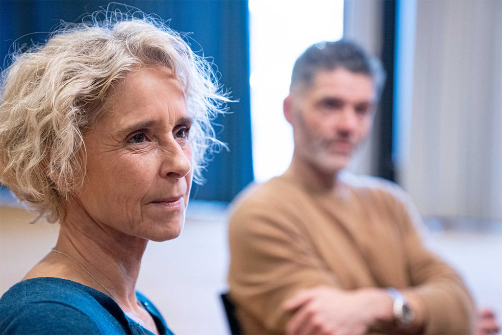Forældre sidder med tænksomt og lyttende udtryk i ansigtet